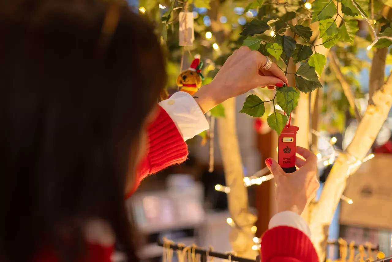 The tree in the Royal Parks shop is being decorated with lights and a postbox decoration