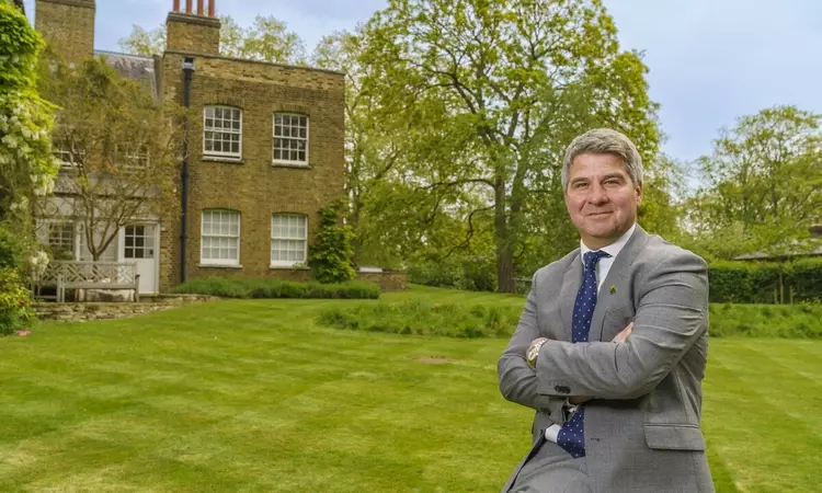 A man in a suit leaning against a bench