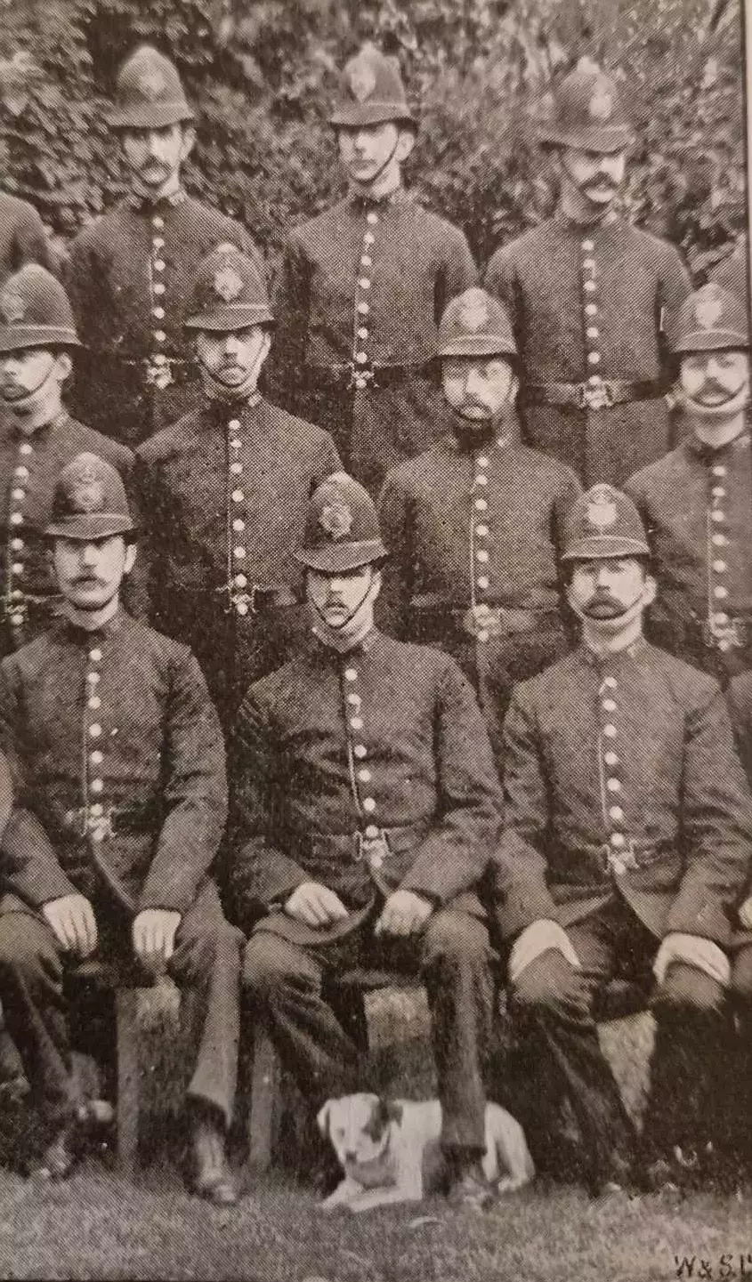 Topper, a dog belonging to the Hyde Park Police Station, posing with his colleagues